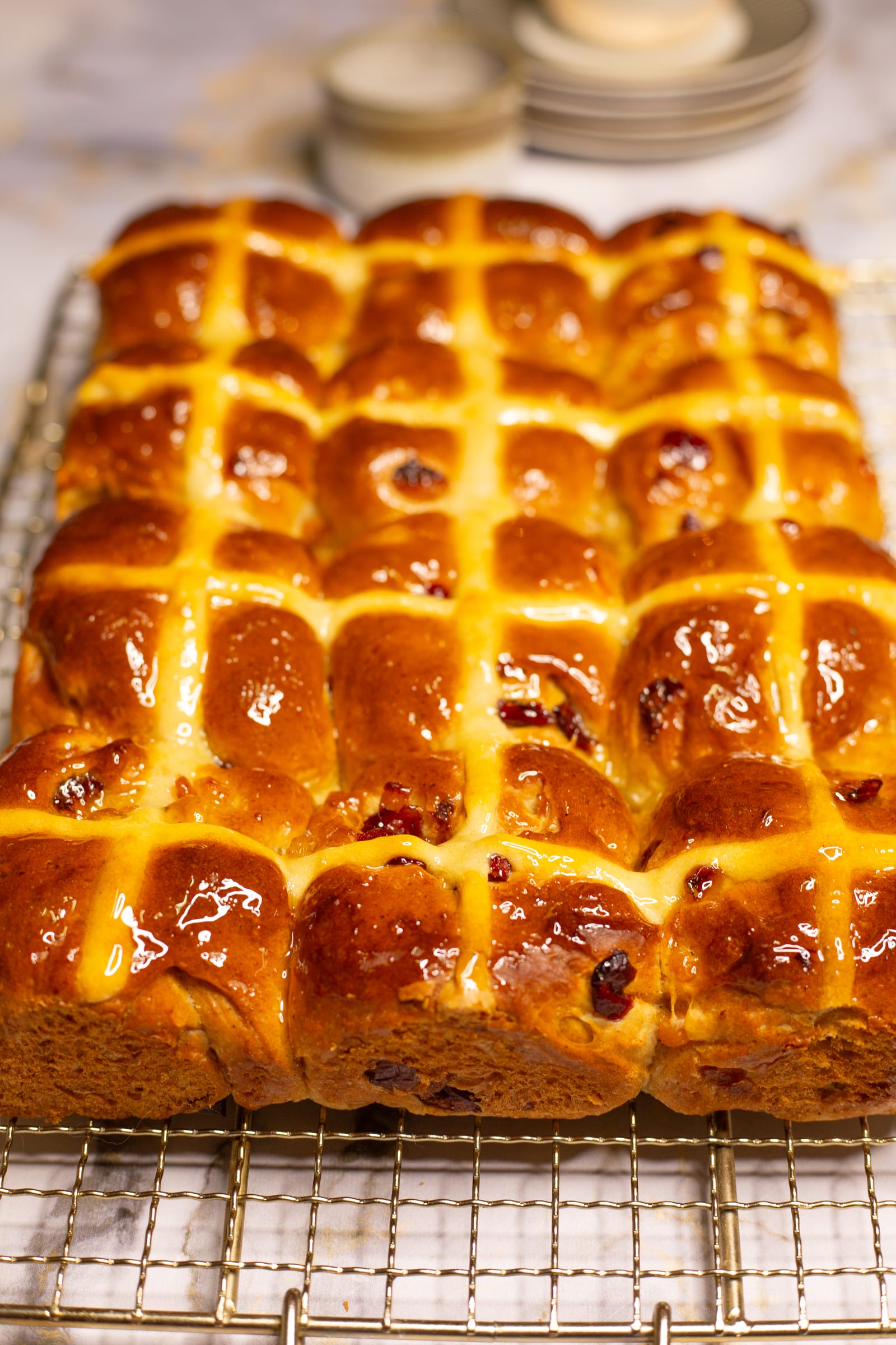 The tray of hot cross buns from the side on a wire rack