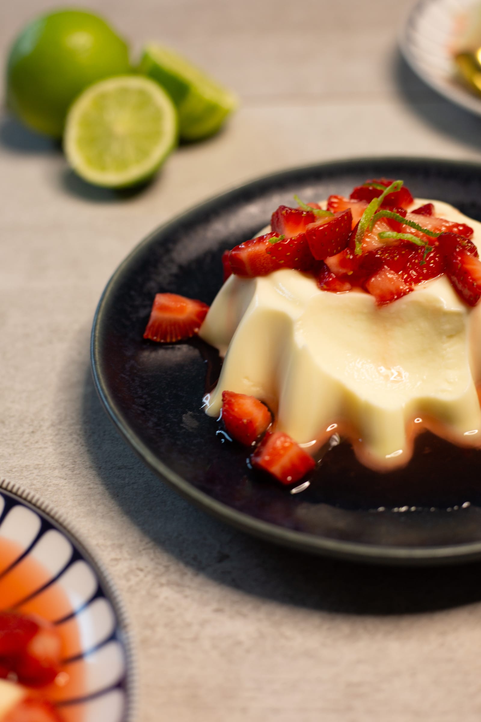 Close-up of a lime panna cotta under its strawberries, from the side