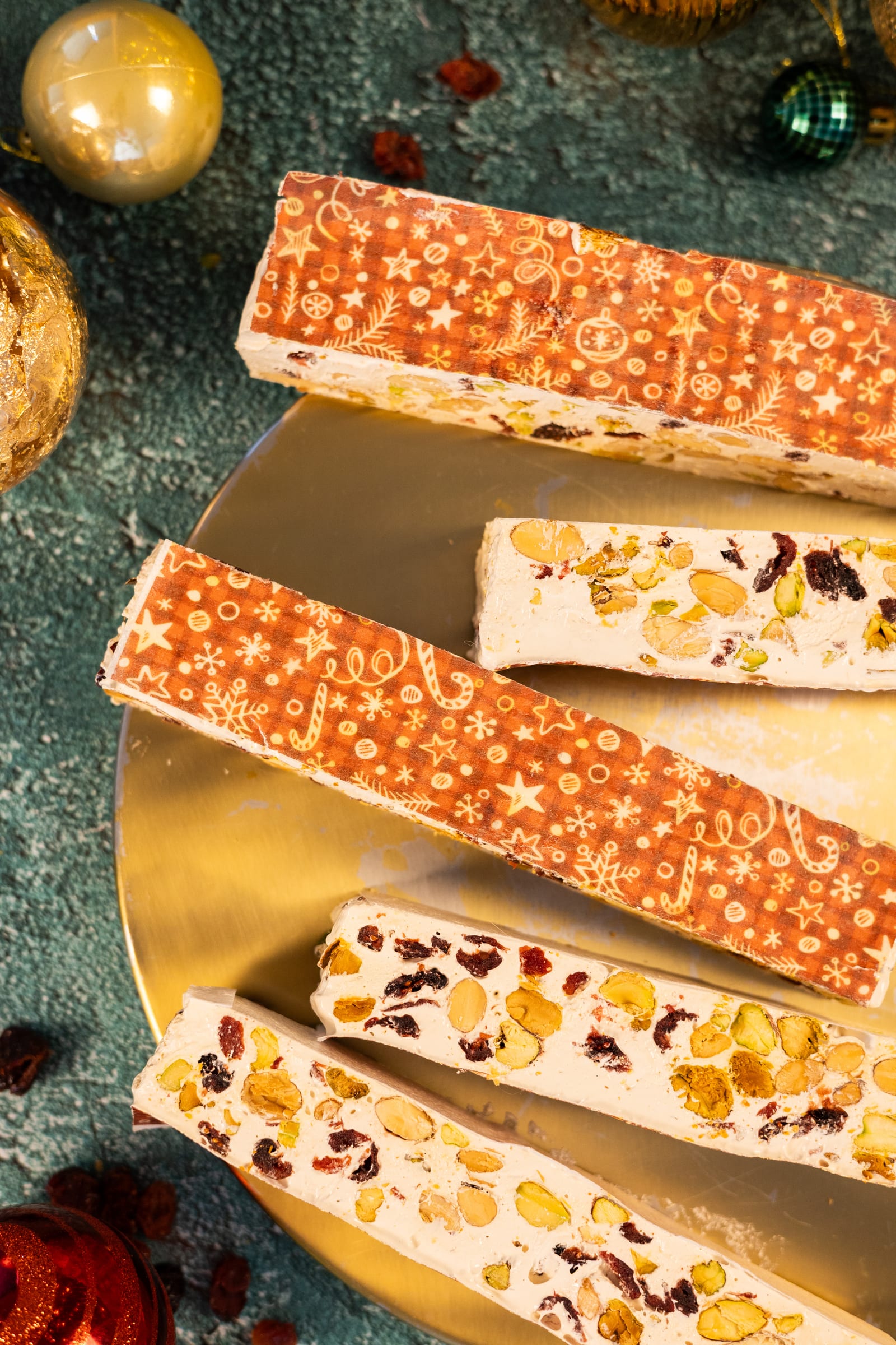 Bars of cranberry and pistachio nougat on a gold plate, from above