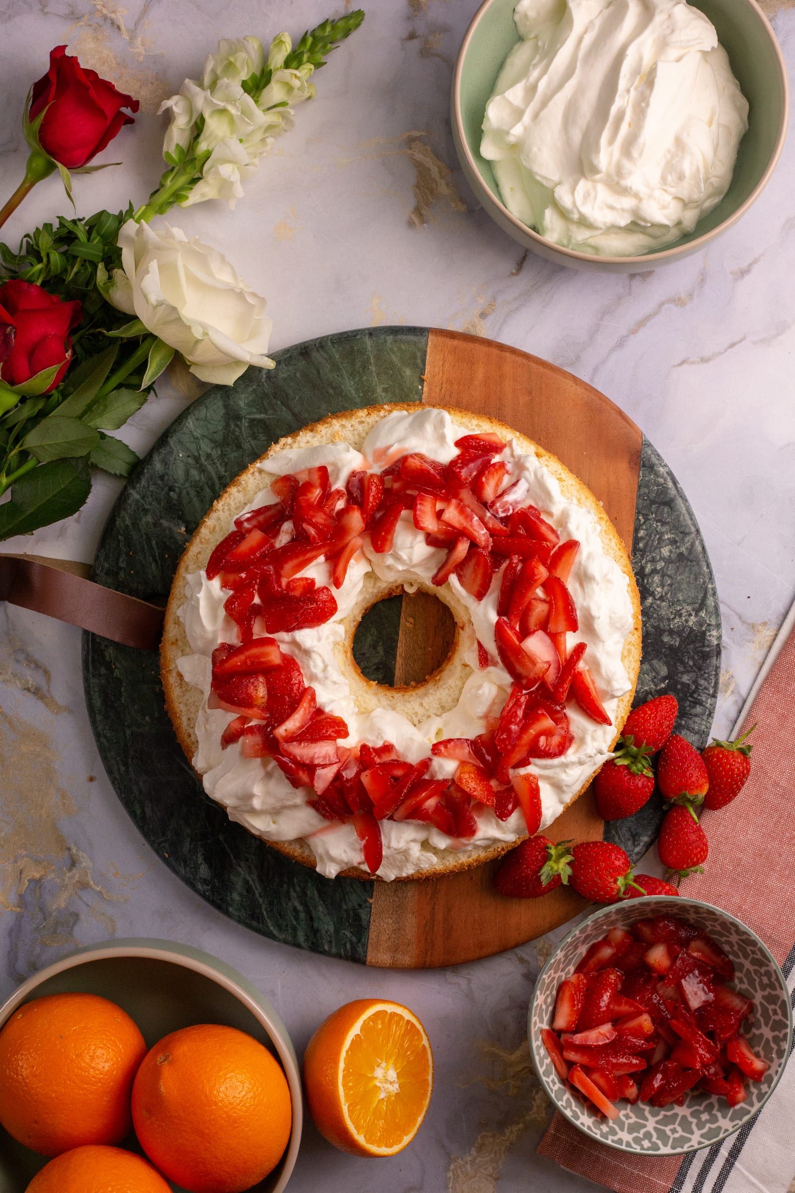 Chopped strawberries over whipped cream on the first layer of angel food cake, from above