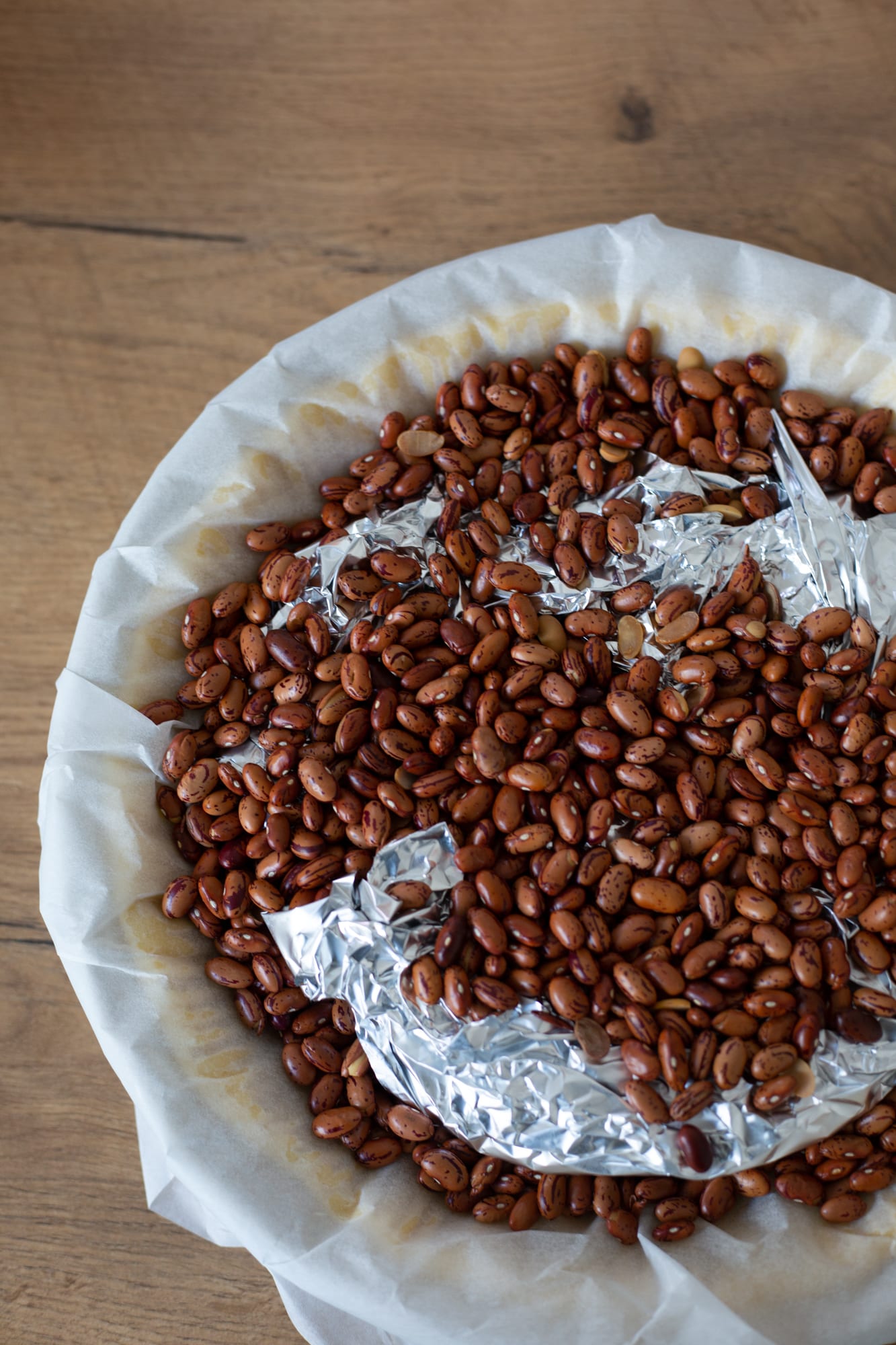 The melktert pastry case being blind baked with baking beans, from above