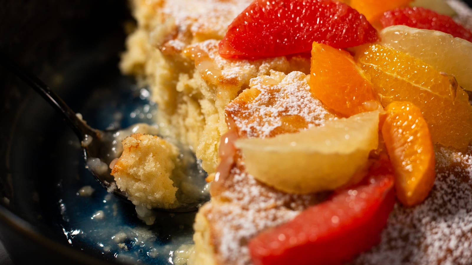 Close-up of grapefruit and orange on the sugar-dusted pudding