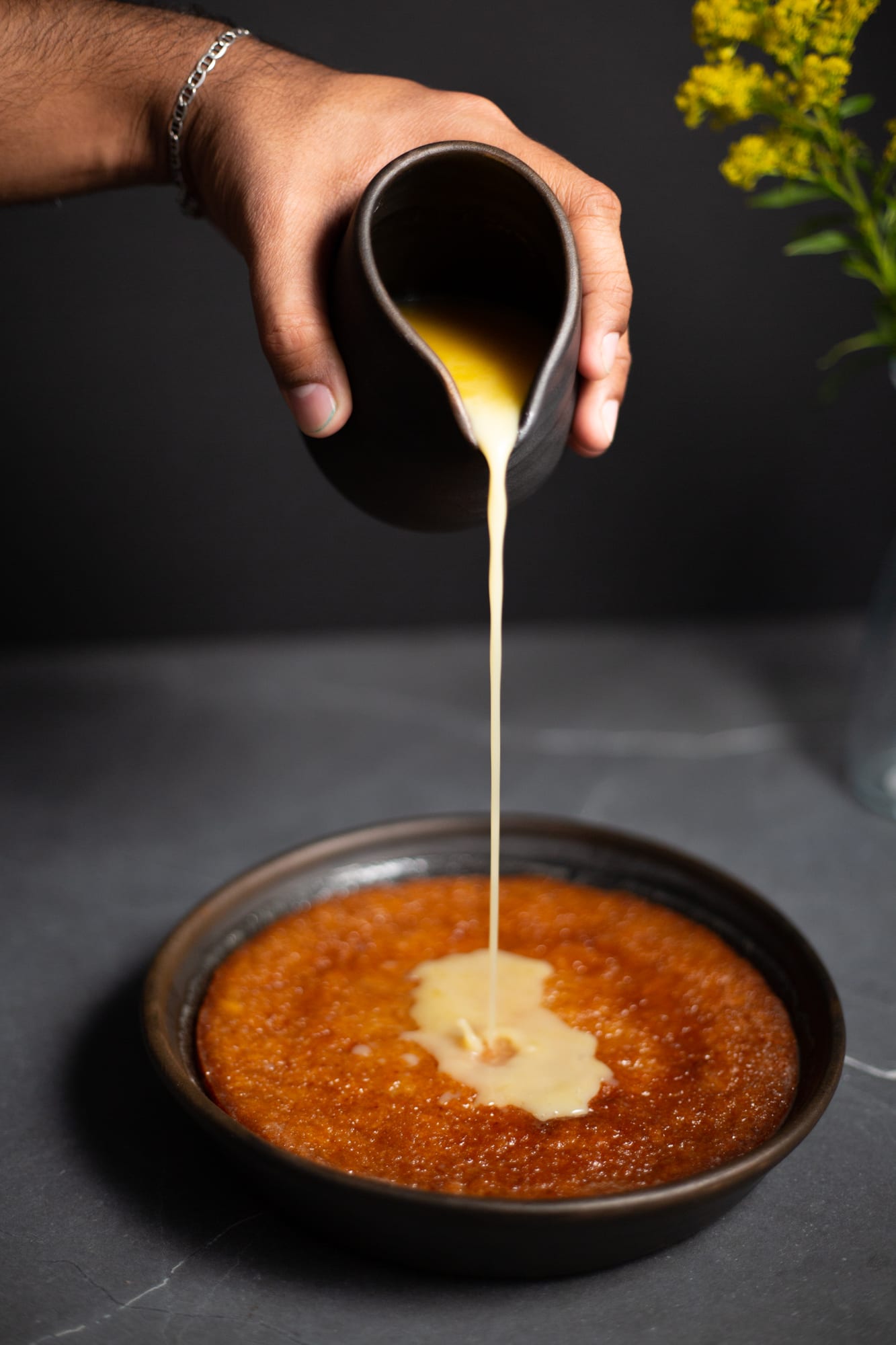 Sauce being poured over the hot malva pudding