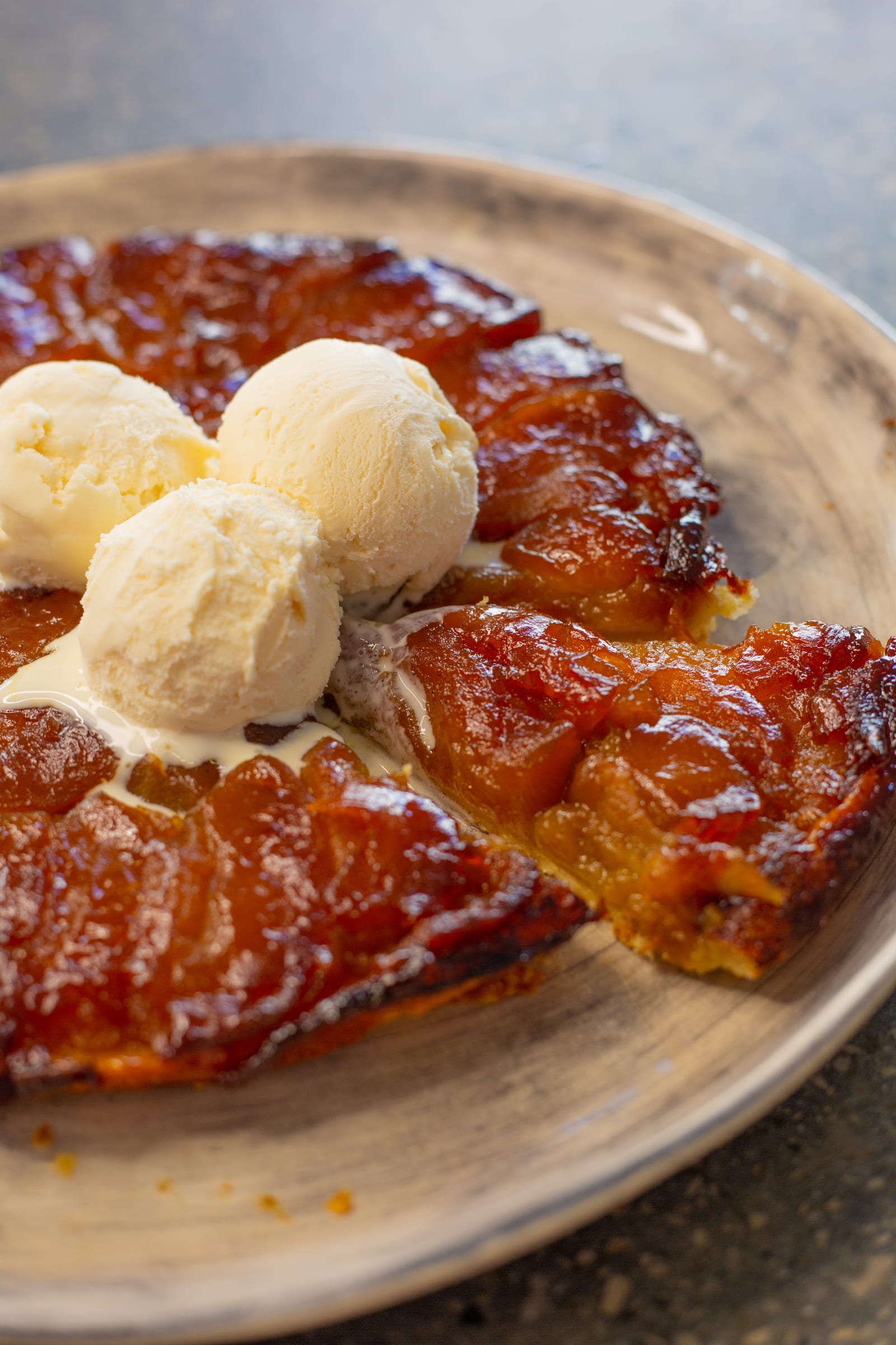 Vanilla ice cream melting on an apple tarte tatin