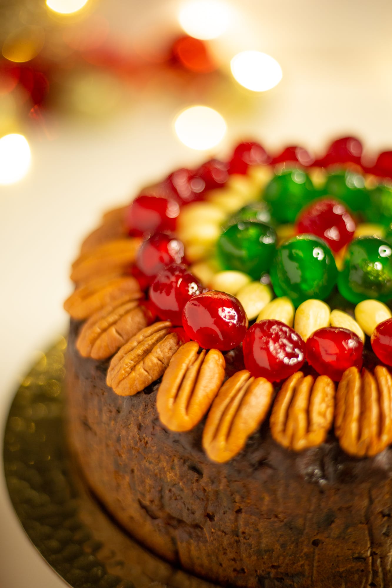 Close-up of the pecans, glacé cherries and almonds on top of a boozy fruit cake