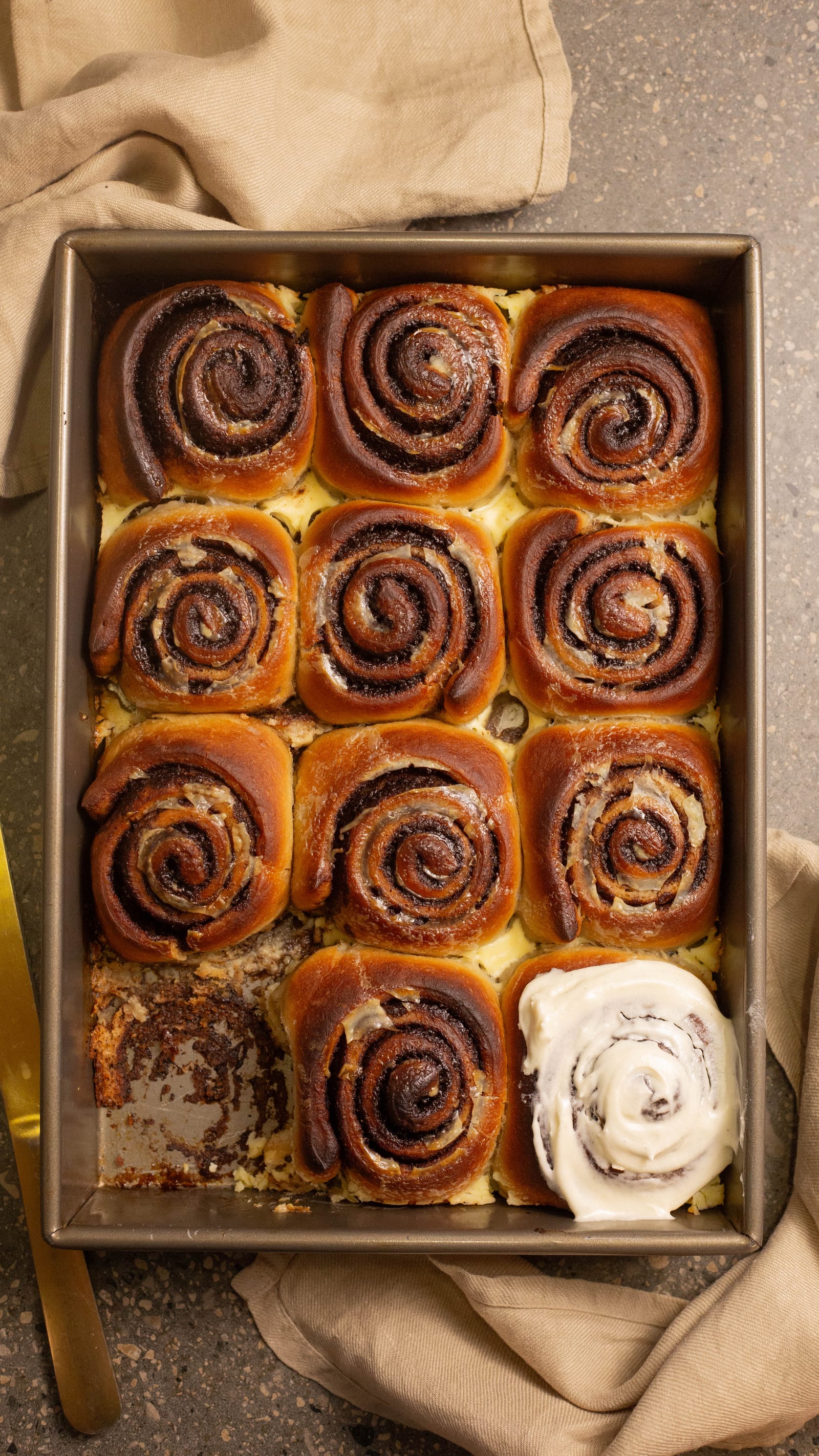 A tin of baked cinnamon rolls before icing, from above