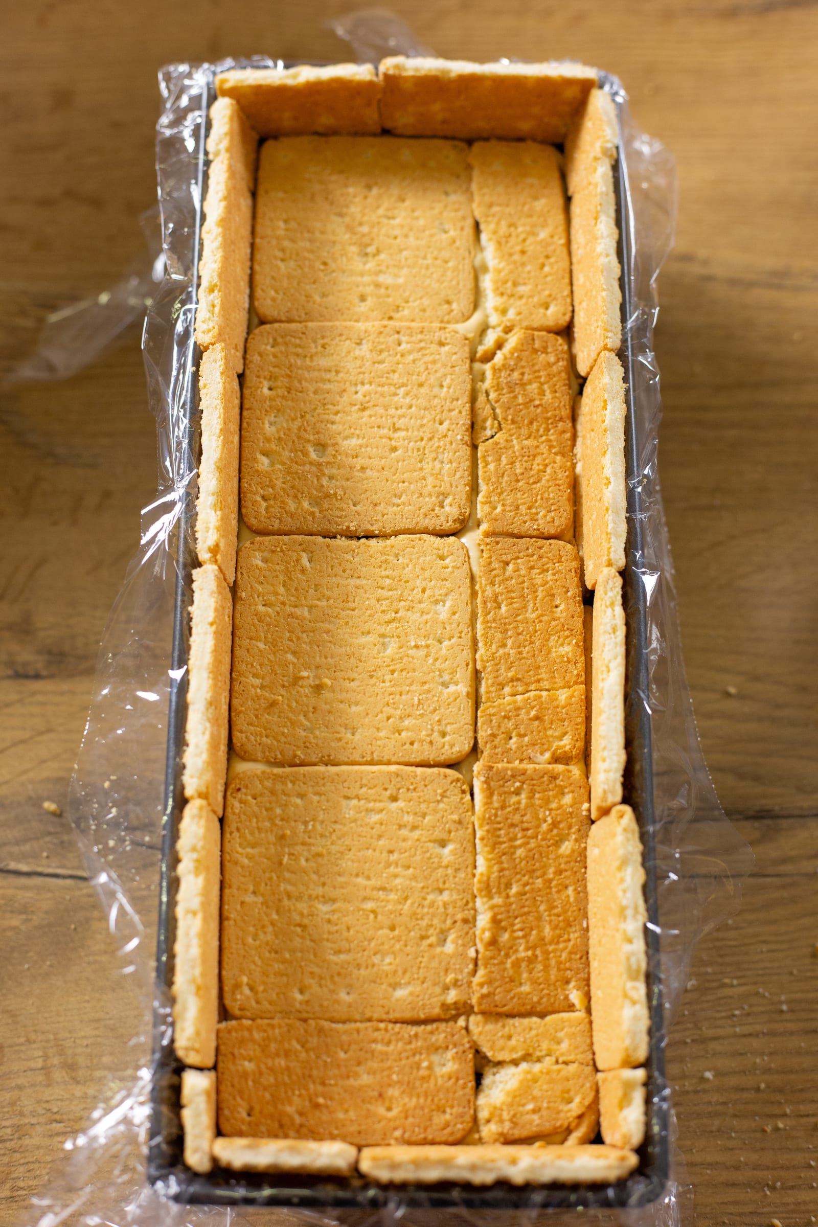 A loaf tin lined with biscuits, ready for the filling