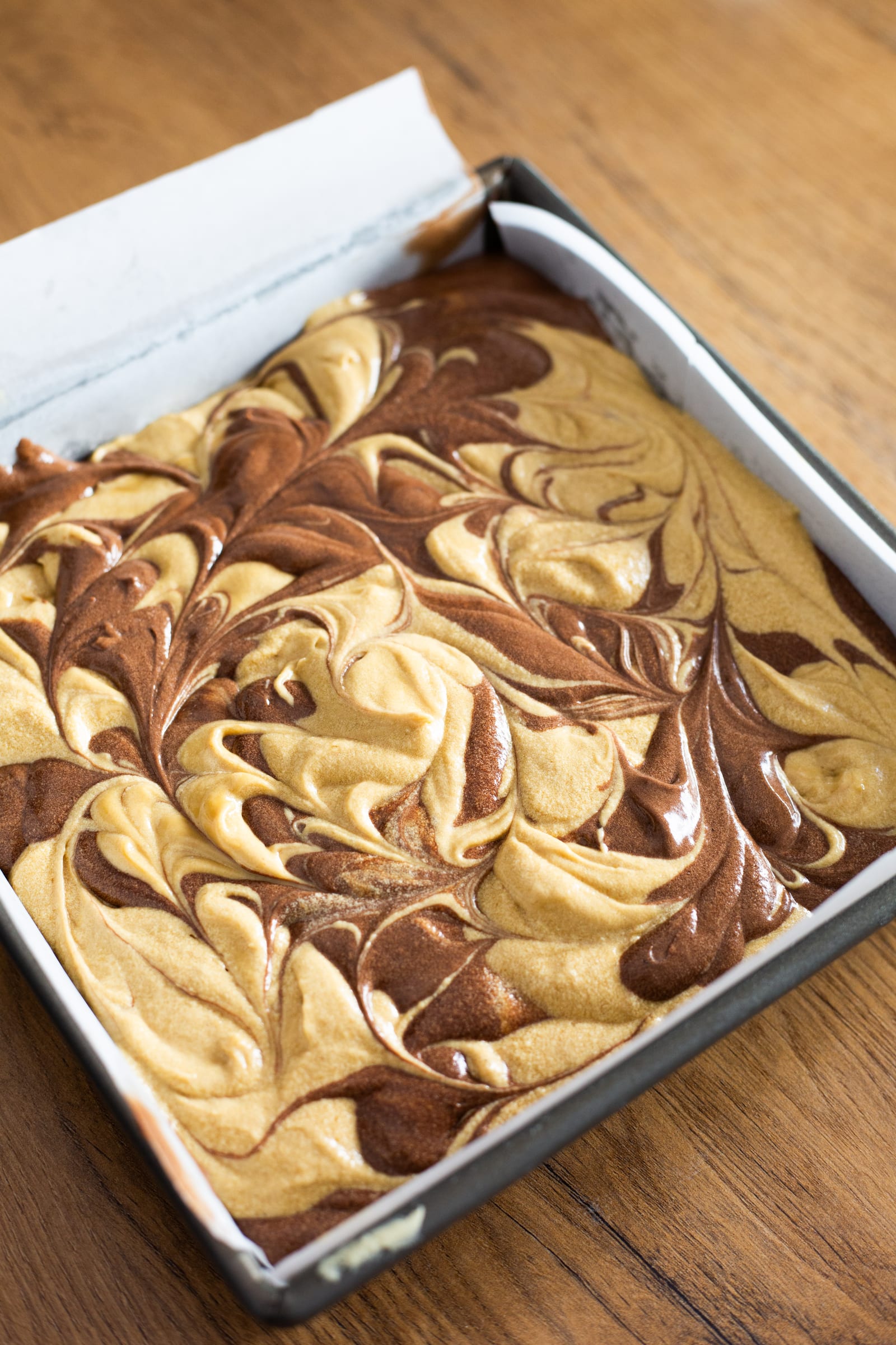 The marbled cake batter in a lined tin, before baking