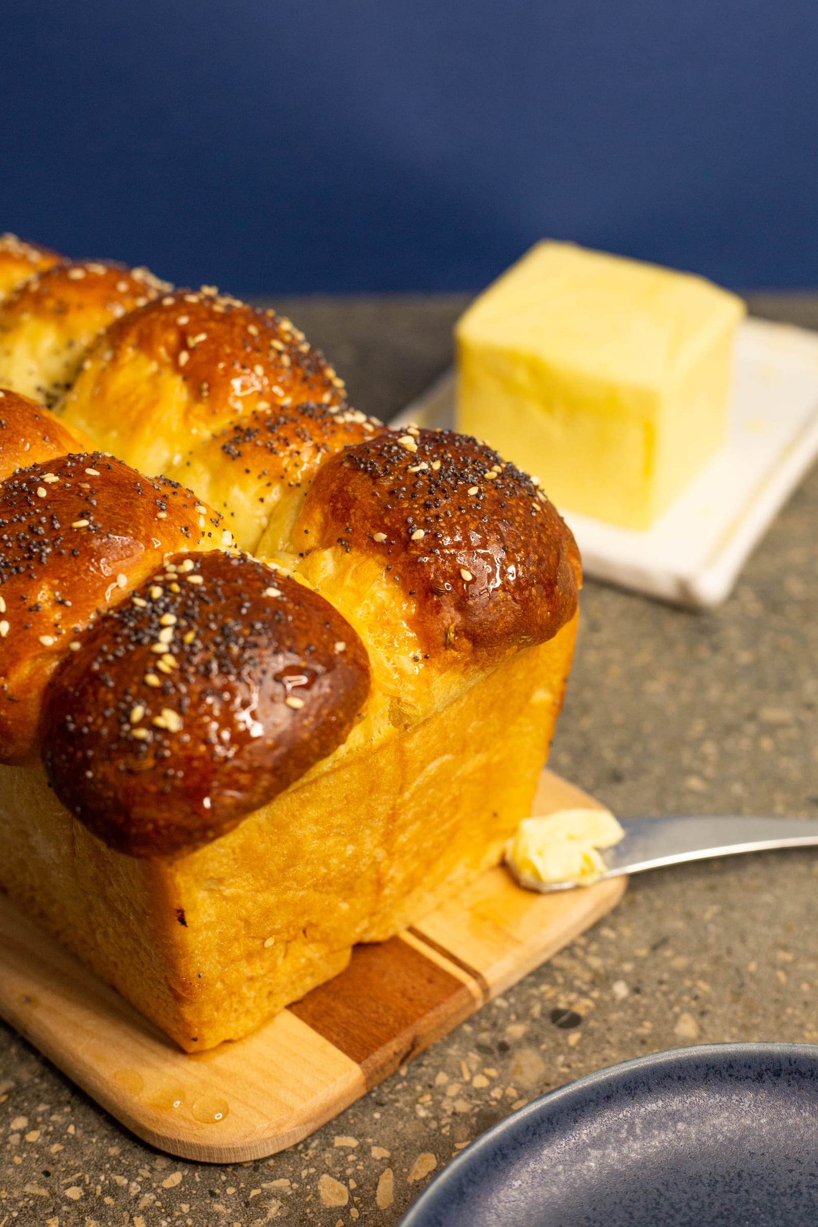 The end of a glossy mosbolletjies loaf with butter alongside