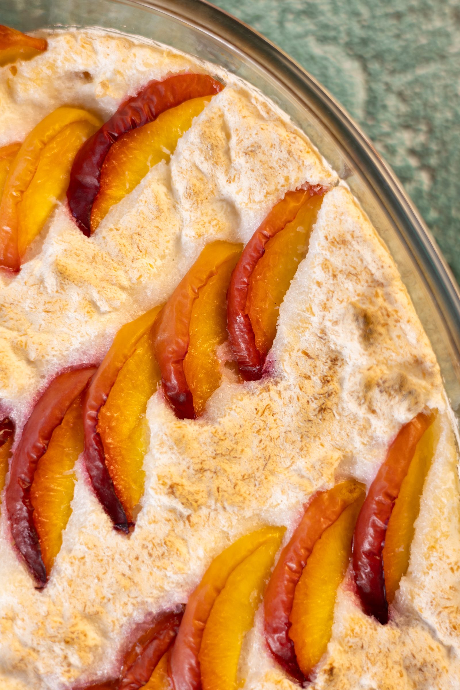 A close-up of nectarine wedges set into the coconut meringue