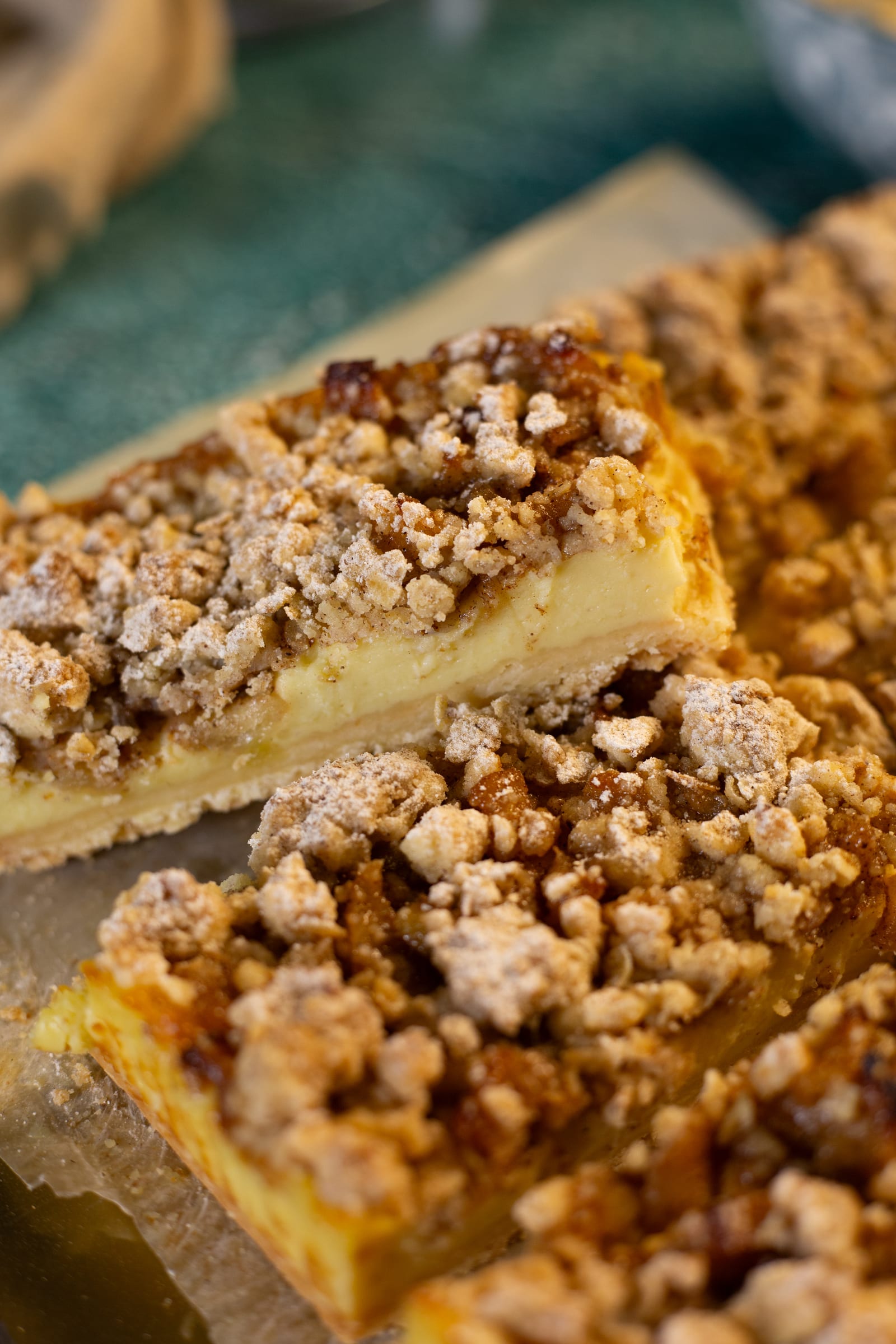 Cut milk tart crumble bars stacked on baking paper