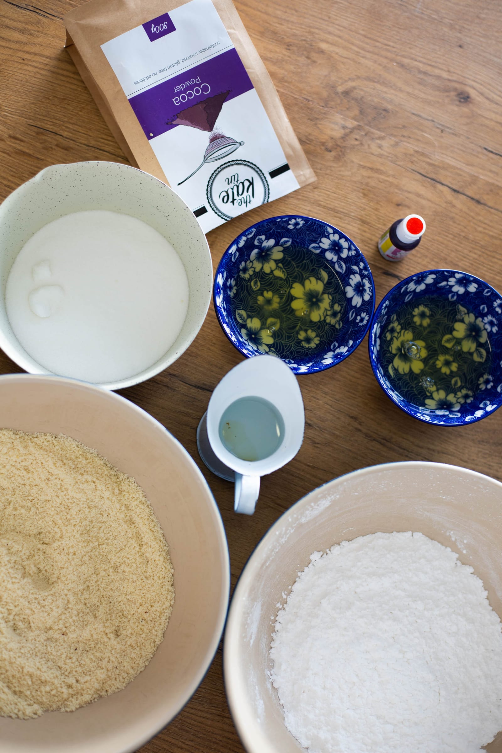 Bowls of almond flour and icing sugar for red velvet macarons, from above